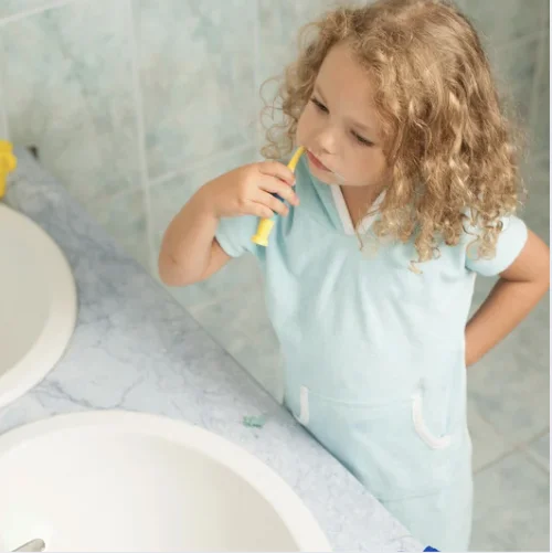 Une petite fille se brosse les dents